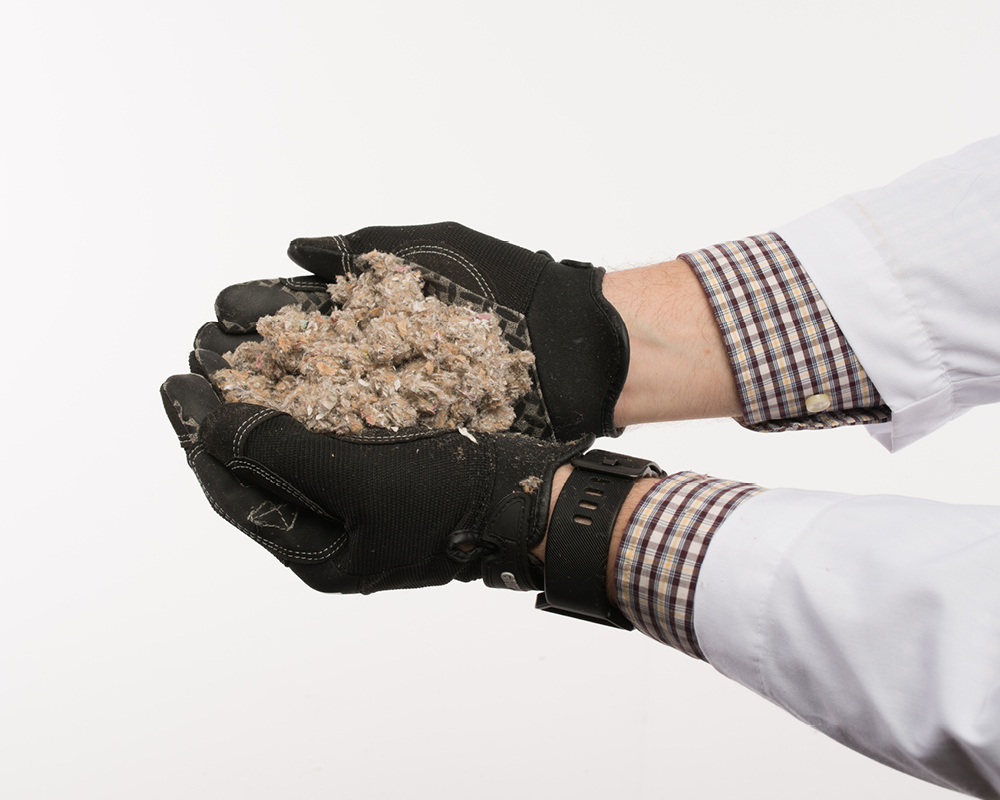 A photo of TAP Insulation being held in the hands of a pest control technician